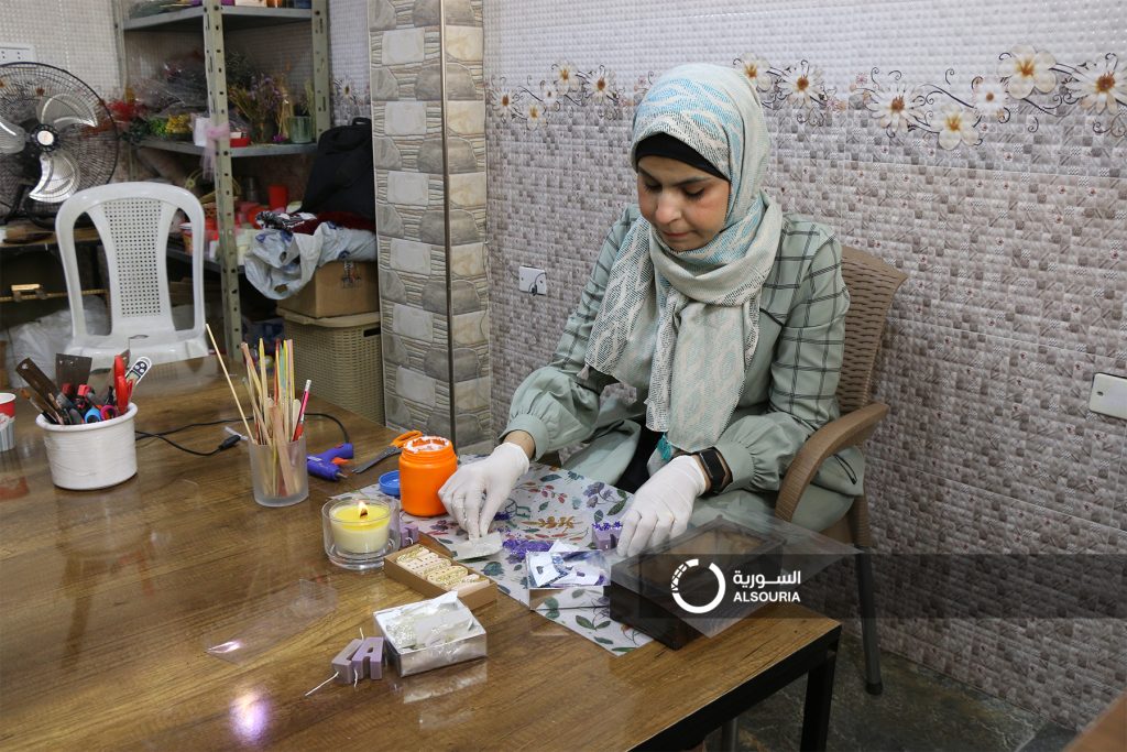 الفنانة أماني العلي تصنّع الشموع في ورشتها (السورية.نت)